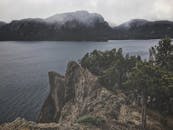 郁郁葱葱的绿色植物环绕着令人叹为观止的岩石悬崖和平静的湖泊