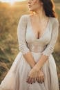 优雅的女人在日落时穿着蕾丝婚纱在户外优雅地摆姿势