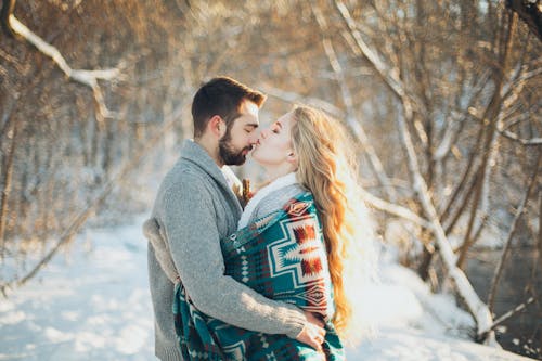 男人和女人互相拥抱，要在下雪季节接吻