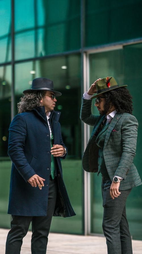Free Two men in fashionable suits and hats pose stylishly in an urban setting. Stock Photo