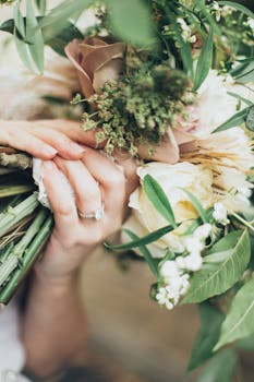 特写镜头中，一只手握着一束郁郁葱葱的玫瑰和树叶，象征着爱与庆祝