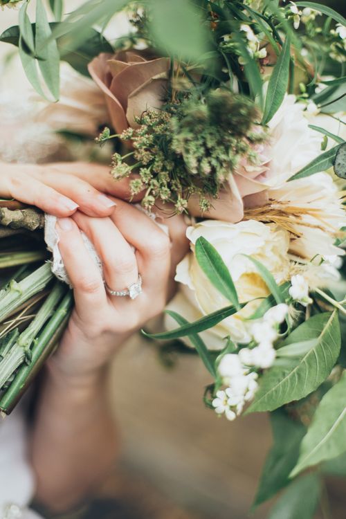 Free Close-up of a hand clutching a lush bouquet of roses and foliage, symbolizing love and celebration. Stock Photo