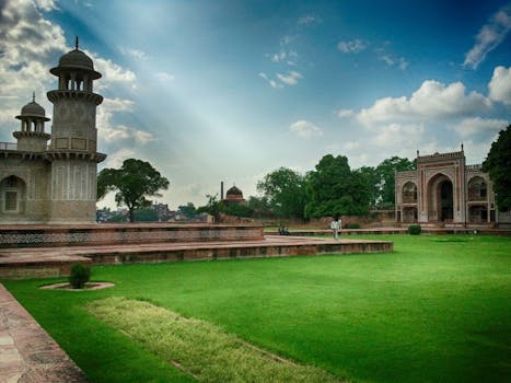 View of the Itimad-ud-Daulah Tomb surrounded by lush gardens and blue sky in Agra, India.