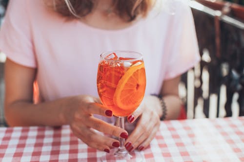 Fotografia Di Messa A Fuoco Selettiva Del Bicchiere Da Vino A Stelo Lungo Trasparente Con Liquido Arancione