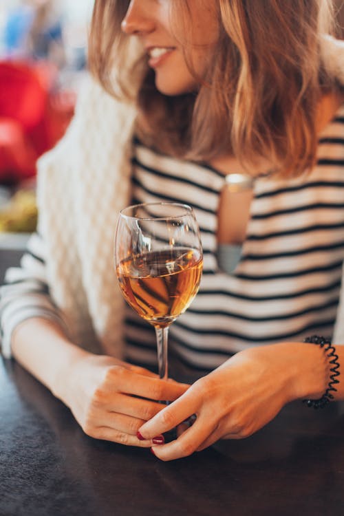 Женщина, держащая бокал вина