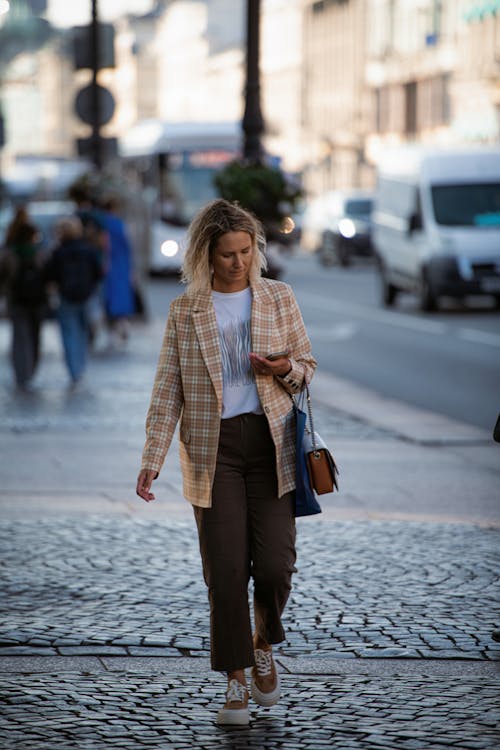 Candid Photo of a Fashionable Woman Walking on a Sidewalk in City 