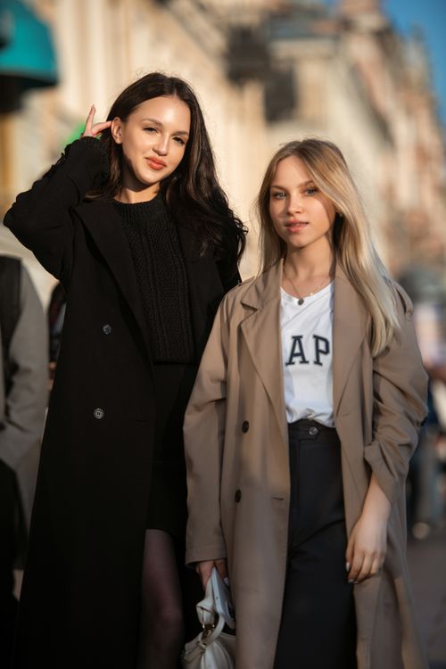 Free Two stylish women pose in urban street fashion under sunlight. Stock Photo