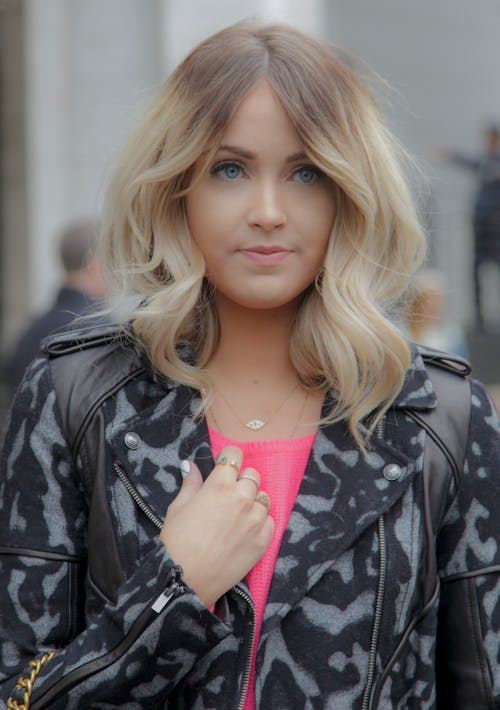 Blonde Wearing a Pink Blouse and a Patterned Jacket