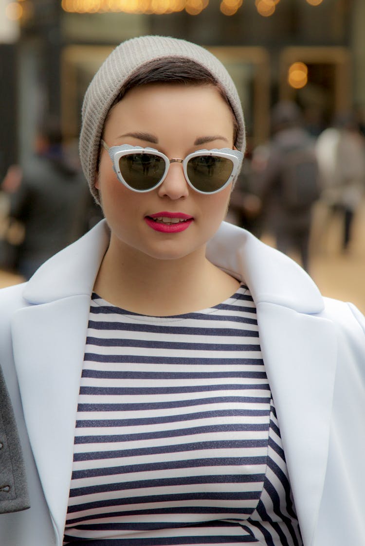 Portrait Of A Fashionable Woman In A Striped Top And Sunglasses Standing Outside 