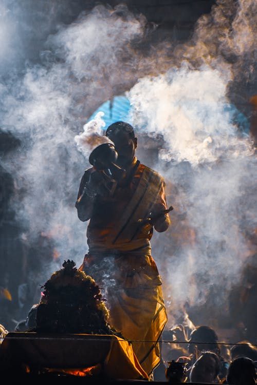 A Man in Traditional Clothes Standing in Smoke during a Traditional Ritual 