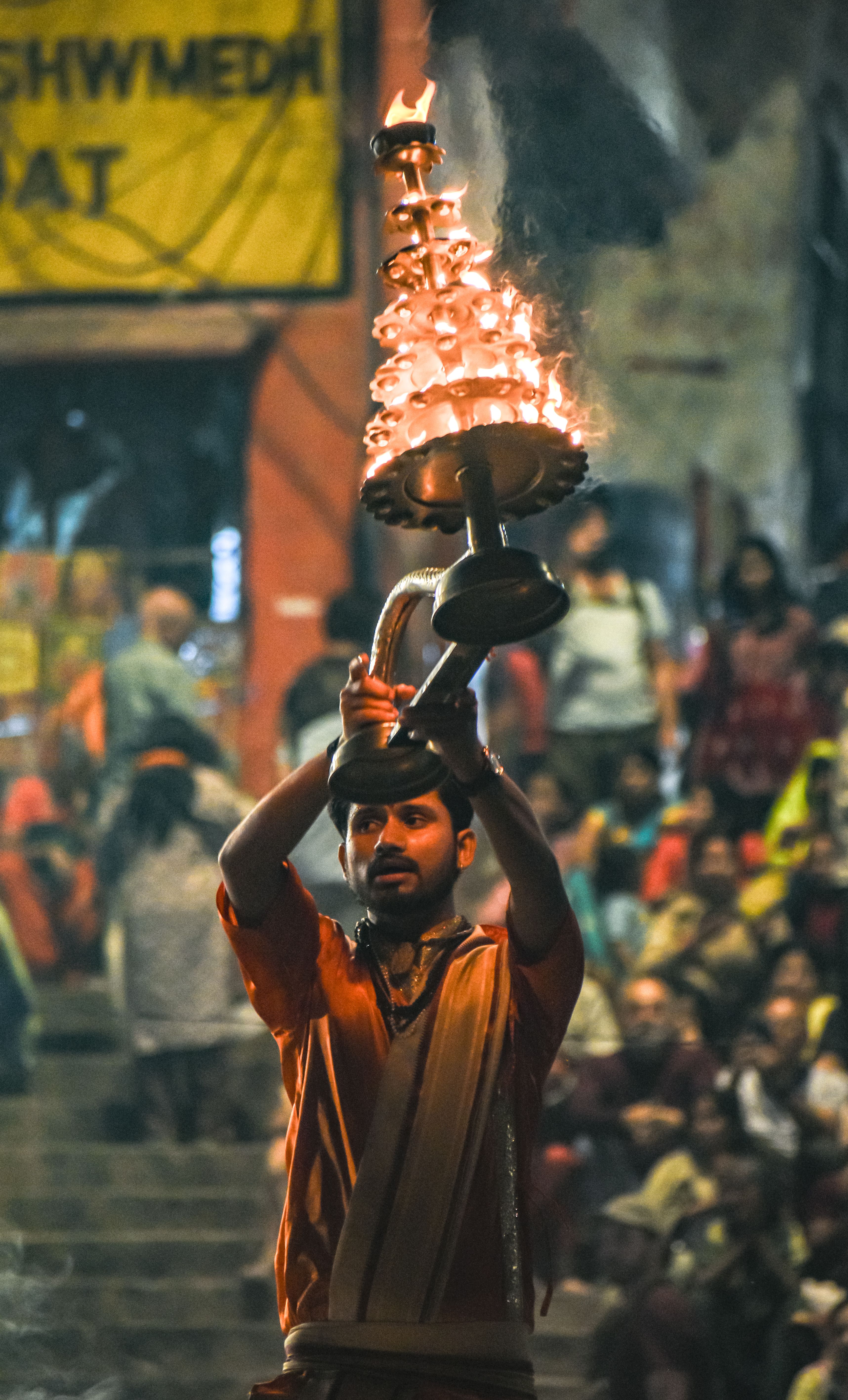 A Hindu priest performs the Ganga Aarti ceremony with a burning lamp by the Ganges River in Varanasi, India.