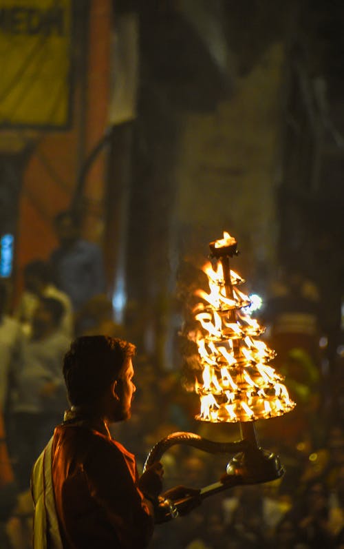 A Man Holding a Stand with Burning Candles during a Traditional Ceremony 