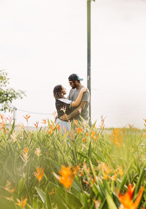 Couple Embracing in a Garden with Orange Flowers 