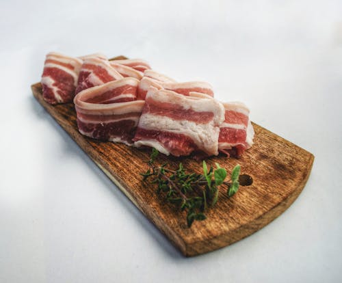 Fotografi Makanan Irisan Bacon Di Atas Papan Pemotong Coklat