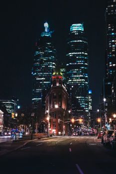 A vibrant night view of Toronto's illuminated skyscrapers and the iconic Gooderham Building.