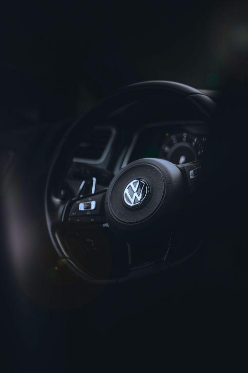 Free Capture of a Volkswagen car's steering wheel in a dimly lit interior, emphasizing its design. Stock Photo