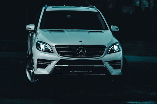Free Front view of a white Mercedes-Benz SUV showcasing stylish design in a moody night setting. Stock Photo
