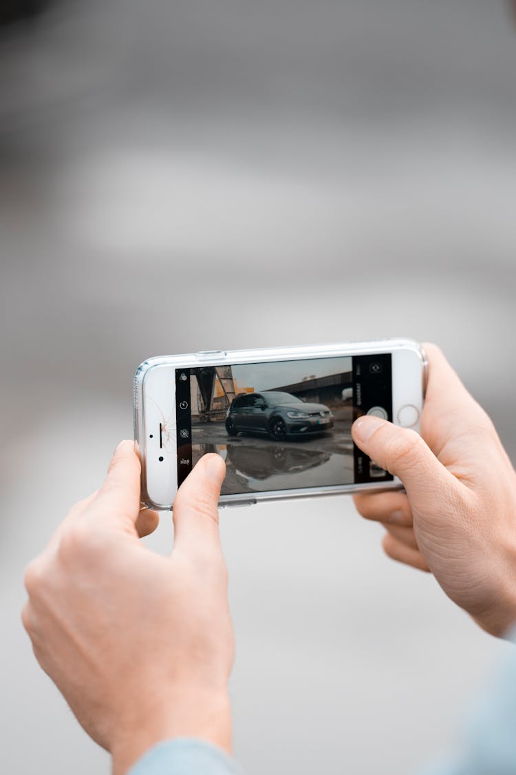 Man Photographing A Car With Smartphone