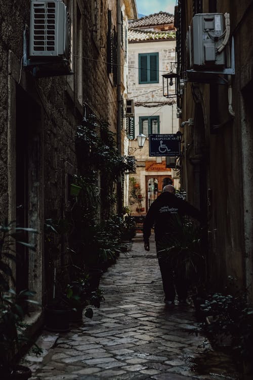 A Narrow Cobblestone Alley between Buildings in City 