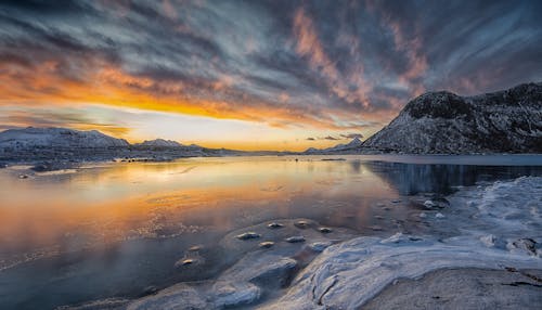 Scenic View of a Body of Water and Mountains at Sunset