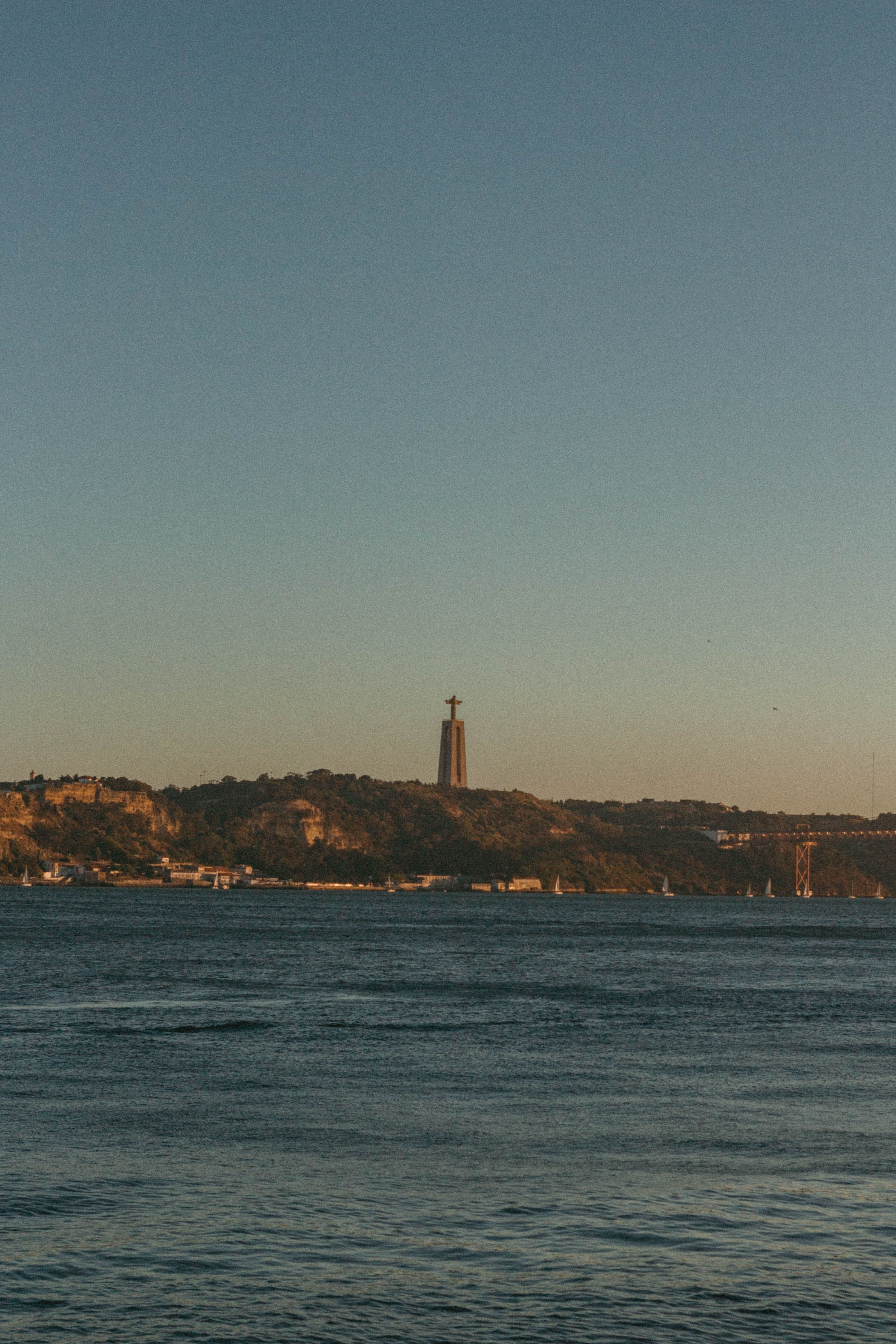 Captivating view of Cristo Rei overlooking the Tagus River at sunset in Lisbon, Portugal.
