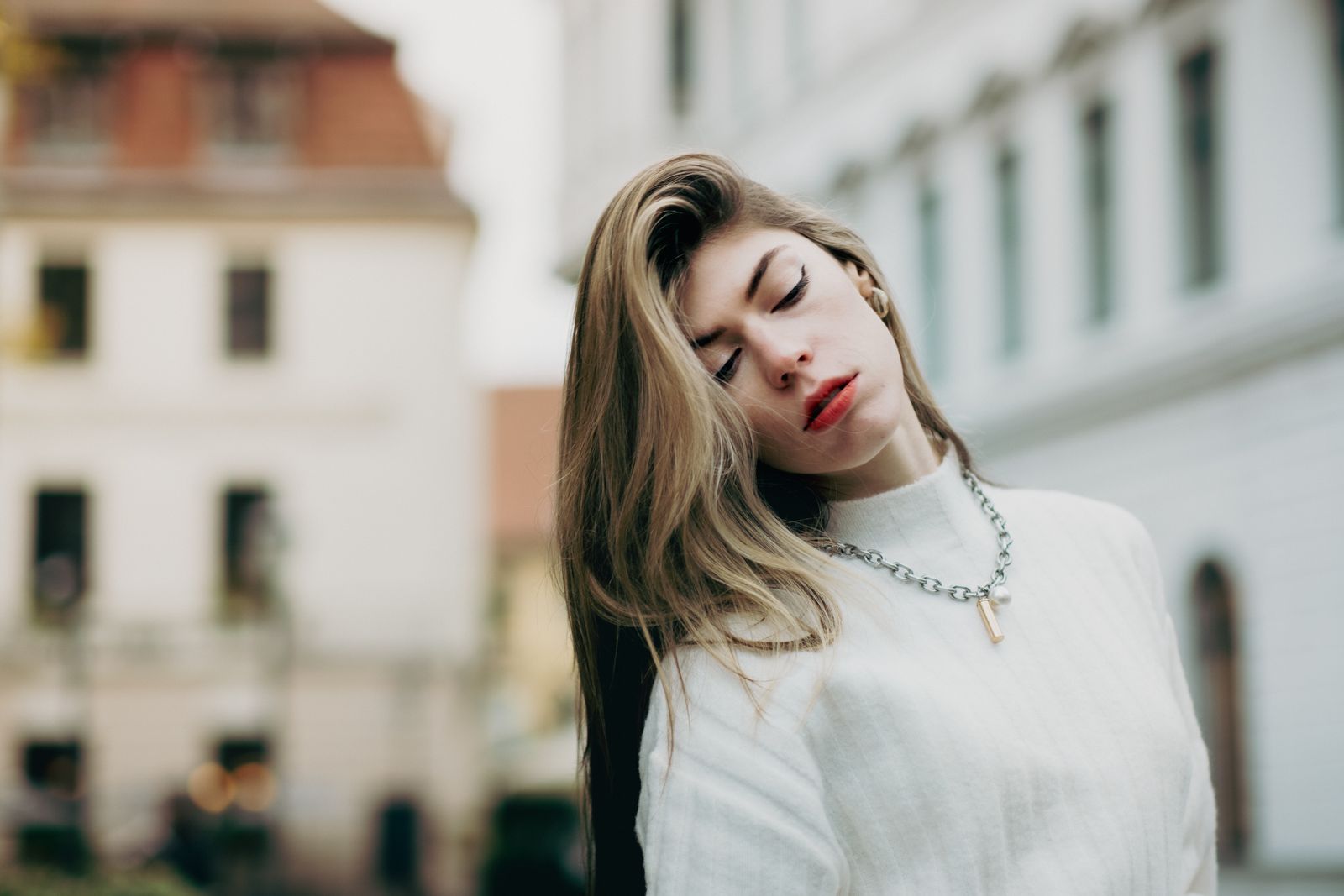 Person gently holding the shoulder and neck area in bright natural light