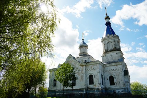 Free Stunning view of an orthodox church's facade with blue domes in a lush countryside setting. Stock Photo