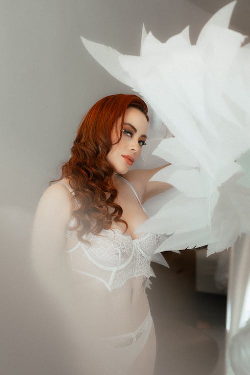 Young Woman Wearing White Lingerie and Angel Wings 