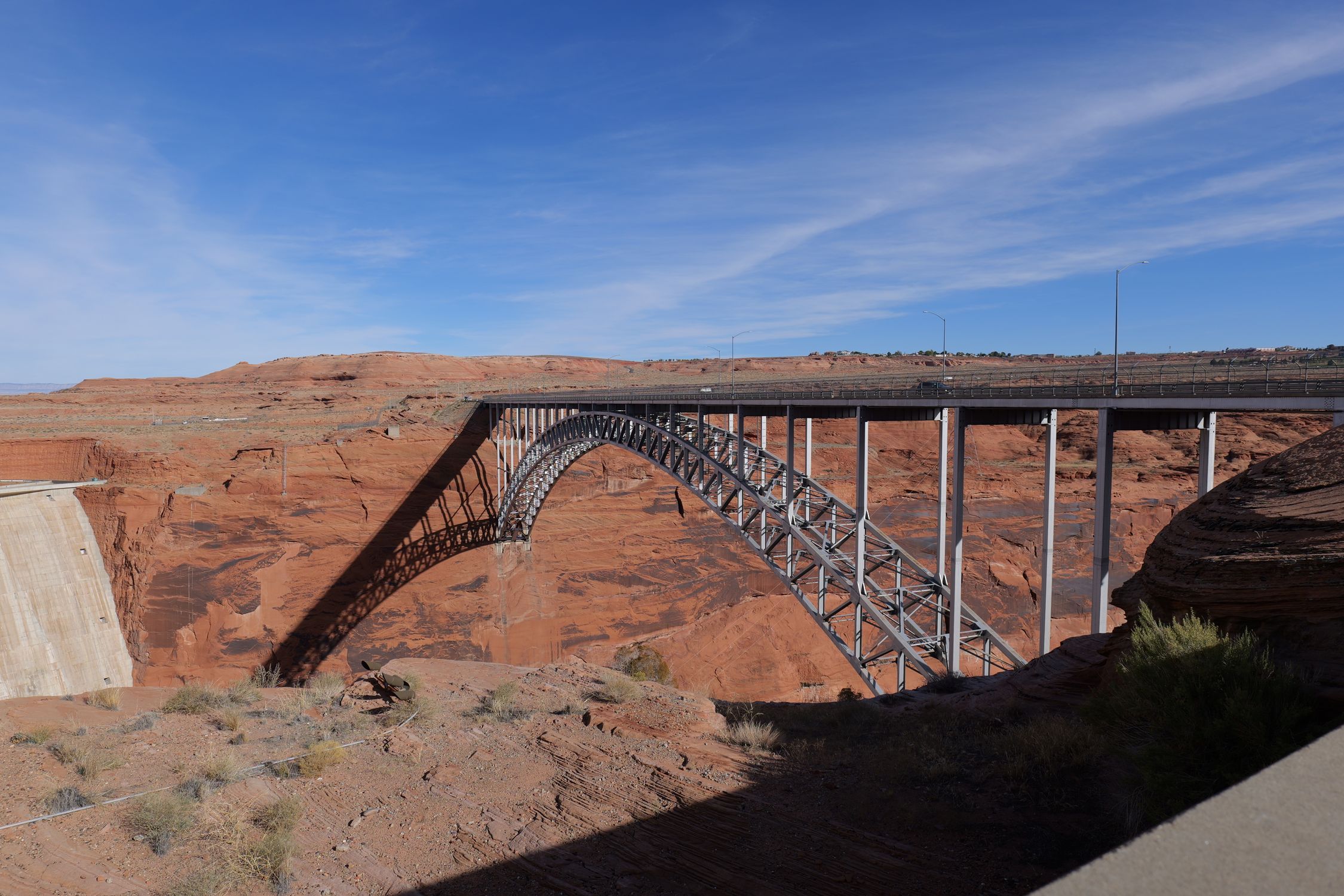 Glen Canyon Bridge spans the sandstone canyon under a clear blue sky in Arizona.