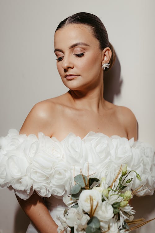 Photo of a Bride Holding the Bouquet and Standing with Eyes Closed