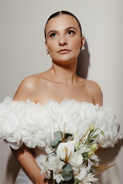 Young Bride in a Wedding Dress Holding Flowers