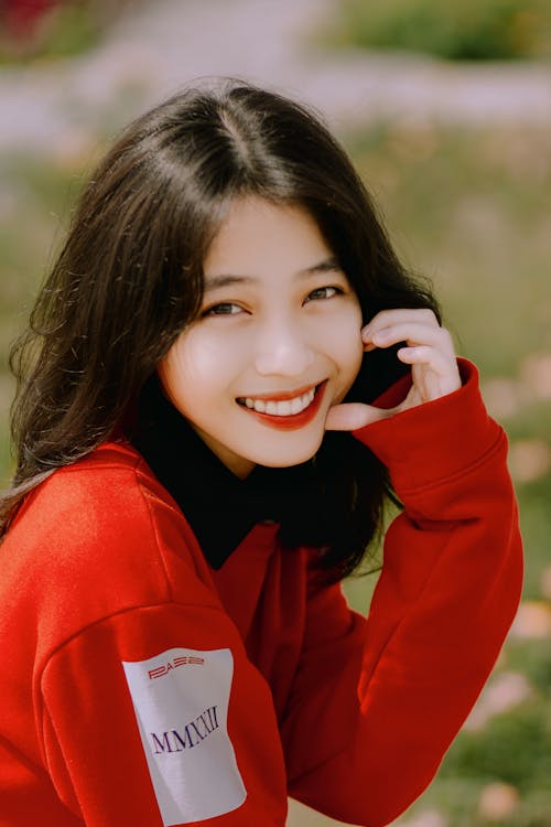Free Smiling Woman Wearing a Red Sweatshirt Stock Photo