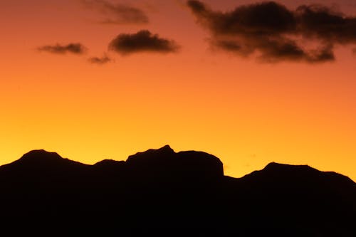 a mountain with sunset in background