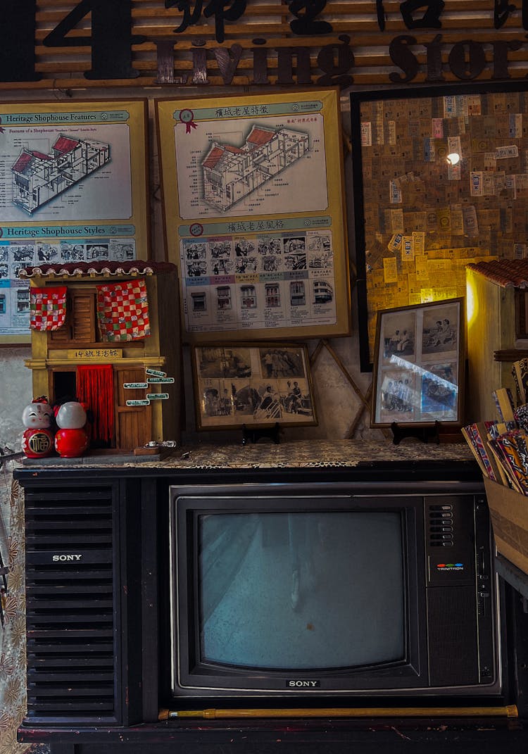 An Old TV And Pictures In Frames Hanging On The Wall 