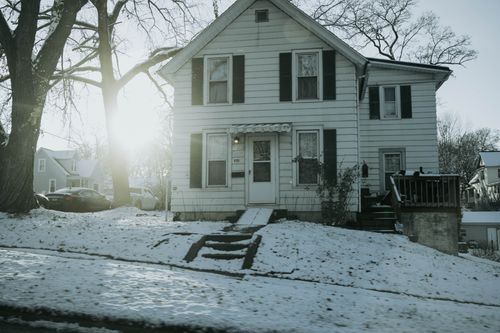Free A suburban house in Dixon, IL covered with fresh winter snow and sunlight shining through trees. Stock Photo