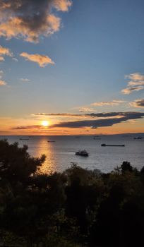 A serene sunset over the sea with ships and distant horizon, captured beautifully.