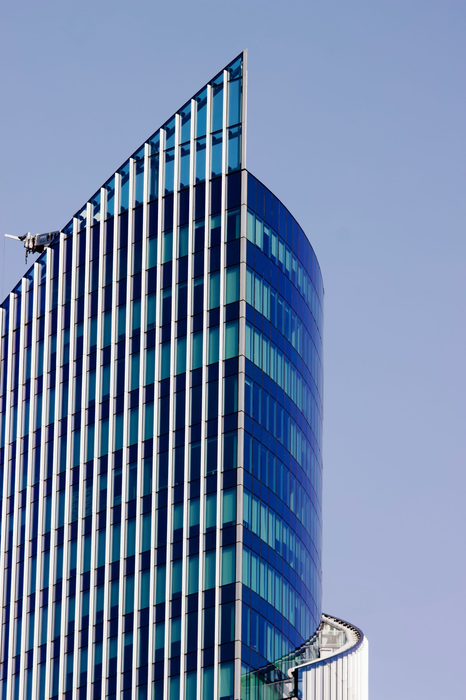 Modern glass office building against a blue sky