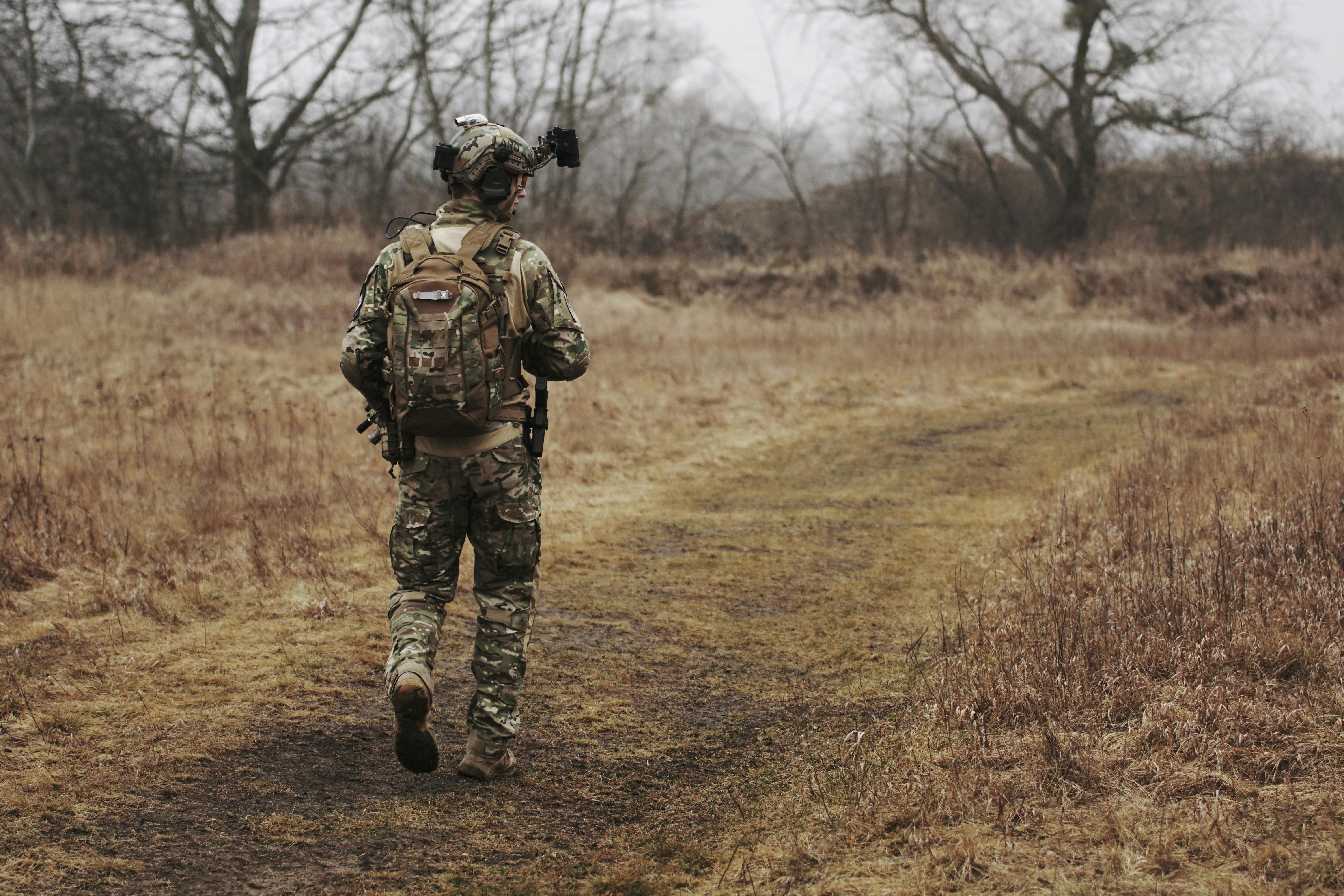 Hombre de pie en traje militar al aire libre