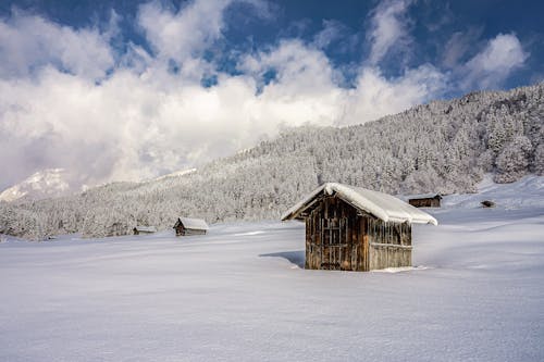 Wooden Hut on Snowy Hillside