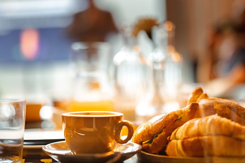 Coffee, toasted bread and fresh pastry arranged on a bakery breakfast table