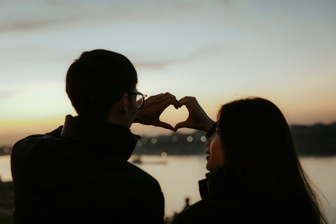 Back View of Couple with Heart Shape from Hands at Sunset · Free Stock ...