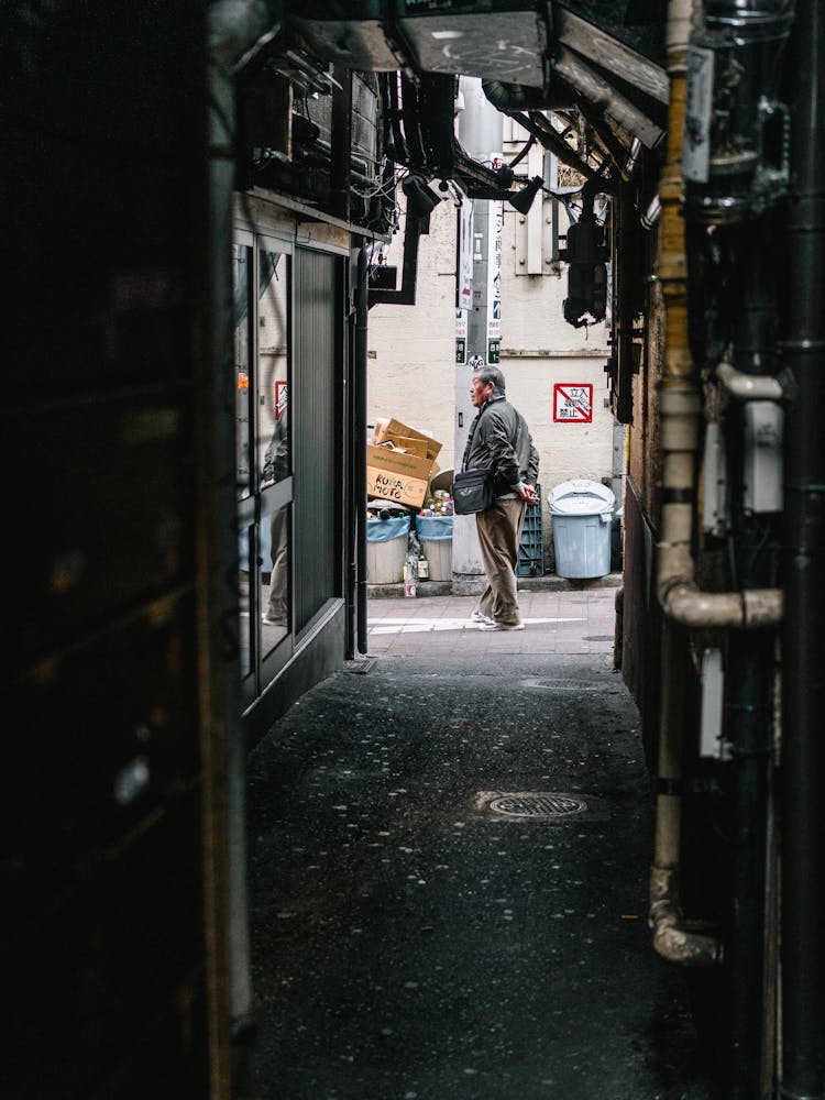 Man Standing Near Trash Can