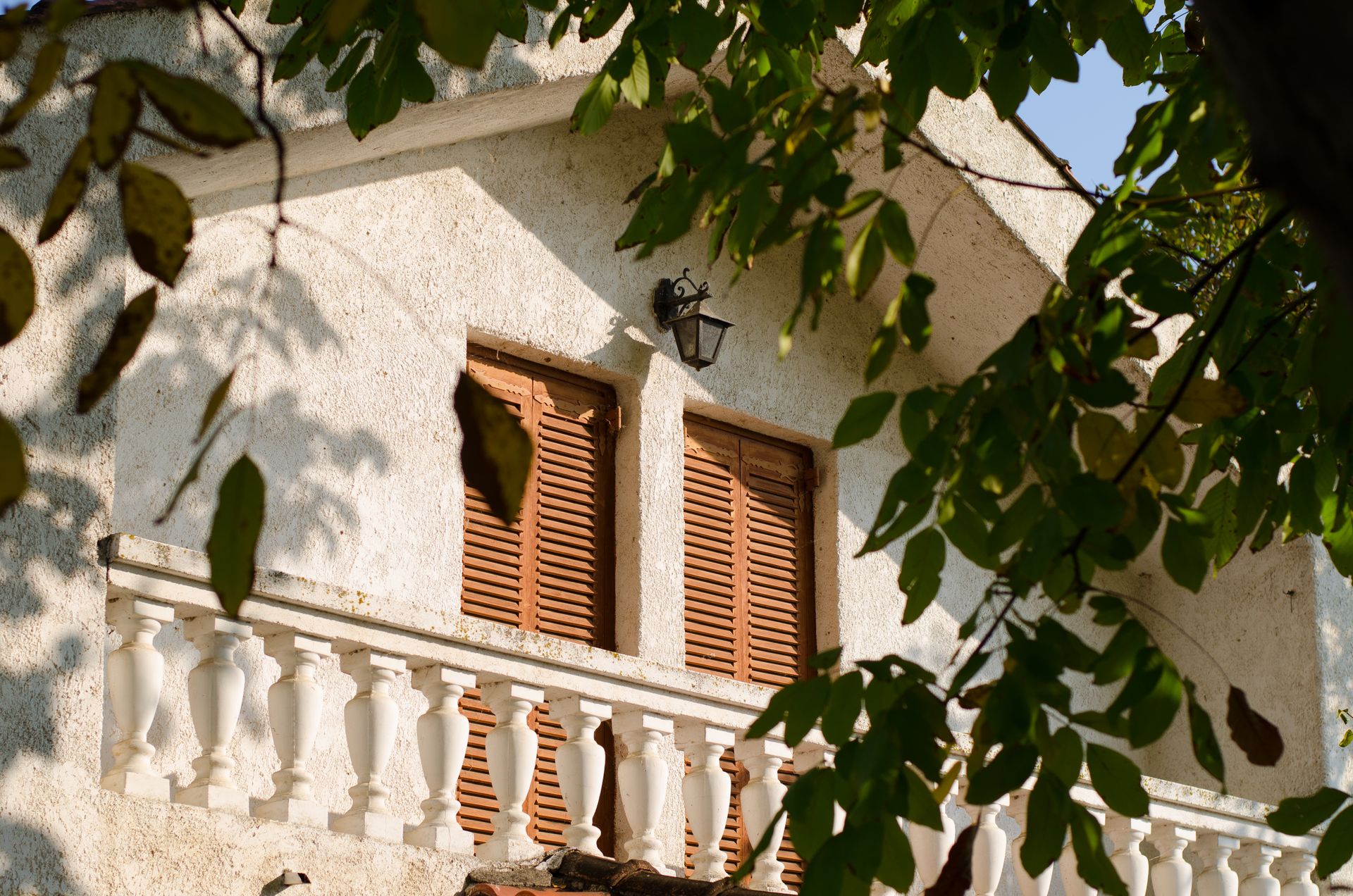 A picturesque Greek villa with wooden shutters and a classical balcony in Karditsa, Greece.