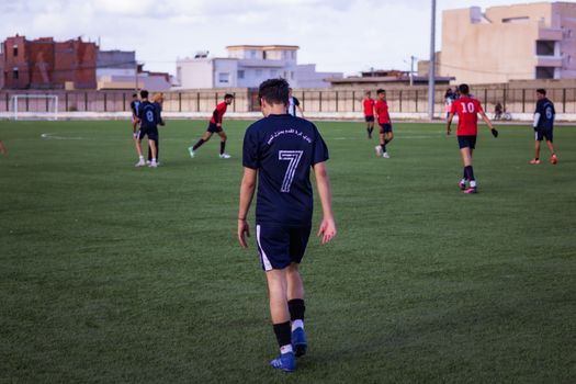 Soccer match in progress with players in action on a green field, focusing on a player wearing number 7 jersey.
