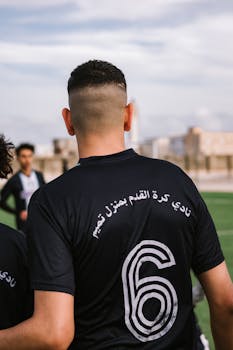 Soccer player wearing number 6 jersey on the field during a sunny day.