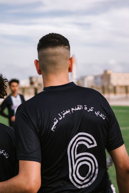 Free Soccer player wearing number 6 jersey on the field during a sunny day. Stock Photo