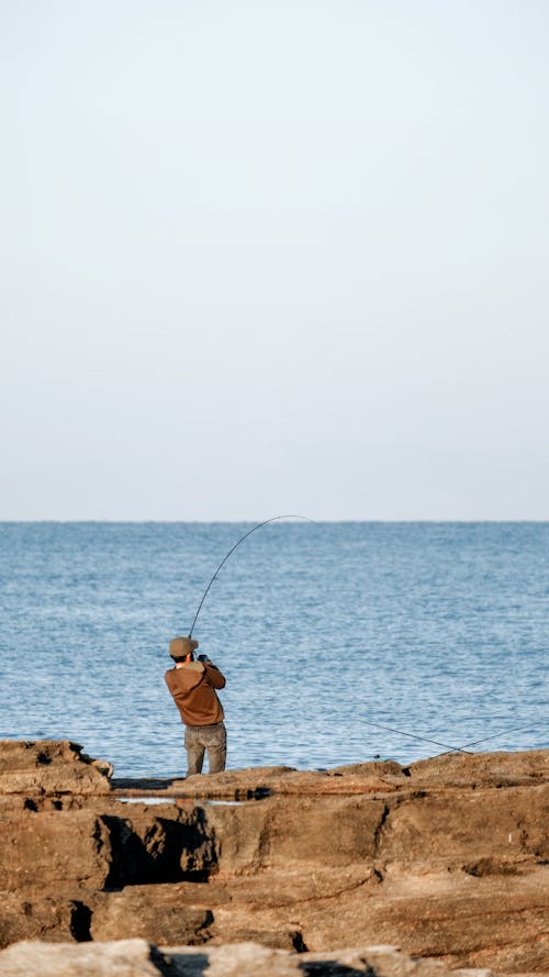 Man Fishing on Sea Coast