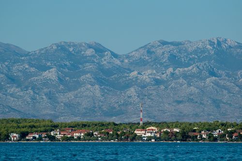 Free Beautiful coastal town in Croatia with majestic mountains and clear blue skies. Stock Photo