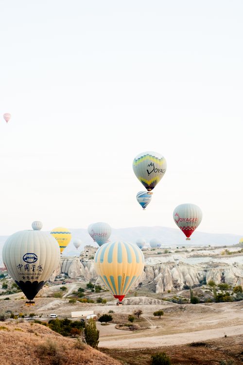 Free Majestic hot air balloons soar over the unique landscape of Cappadocia, Türkiye at sunrise. Stock Photo