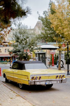 A classic yellow convertible parked on a street in Göreme, Türkiye.